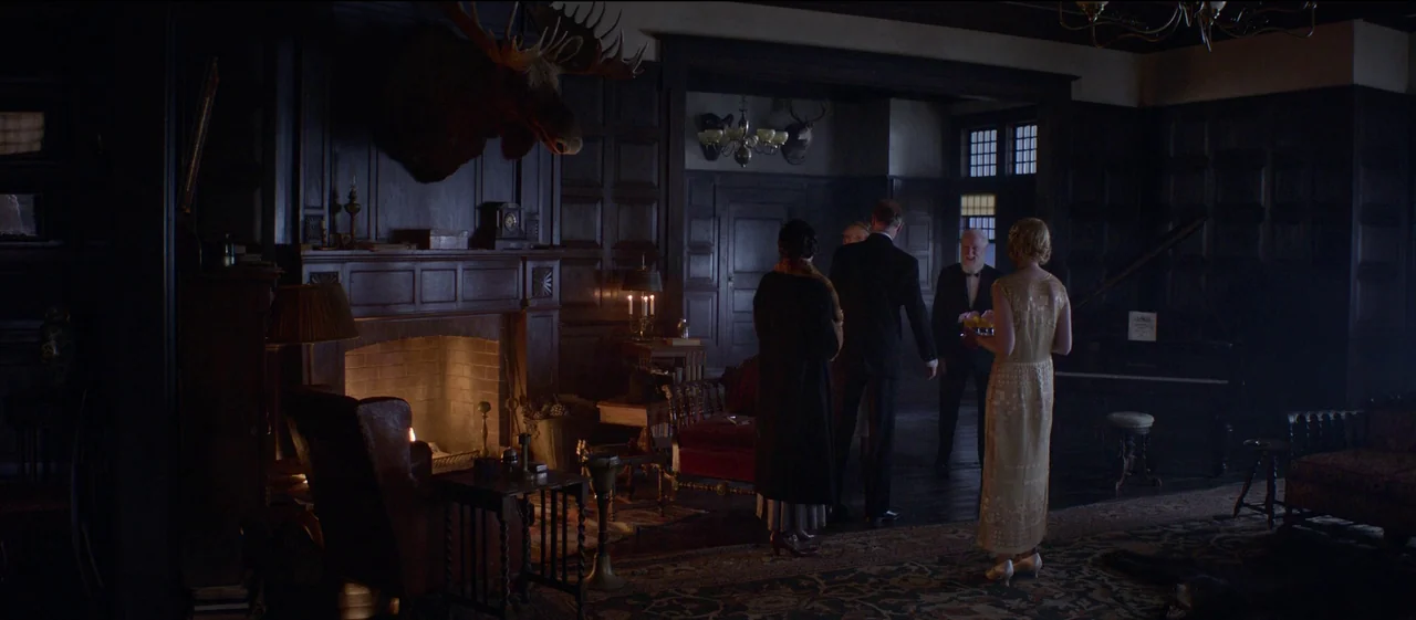 The Power of the Dog (2021) movie still: wide — A spacious wood-paneled room features a large fireplace and taxidermy mounted on the wall. Four…