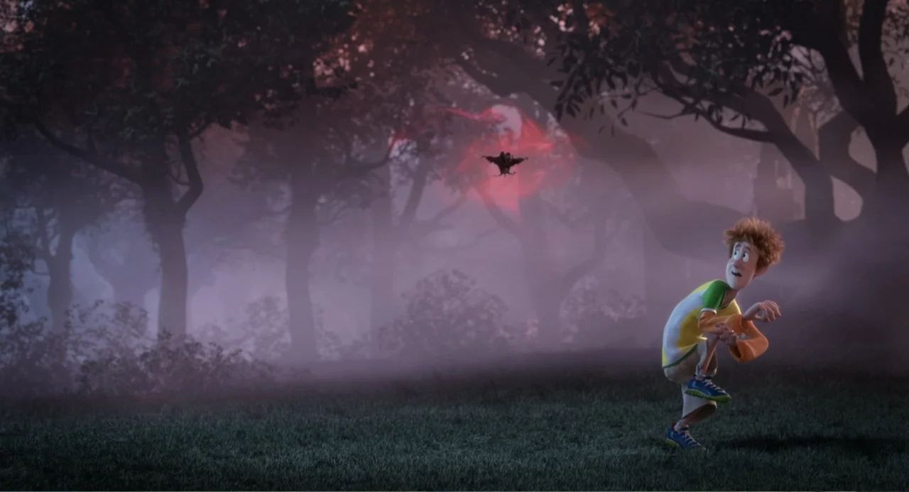 Hotel Transylvania 2 (2015) movie still: wide — A dark, misty woodland area features thick trees and low-lying fog. A teenage boy crouches on the…