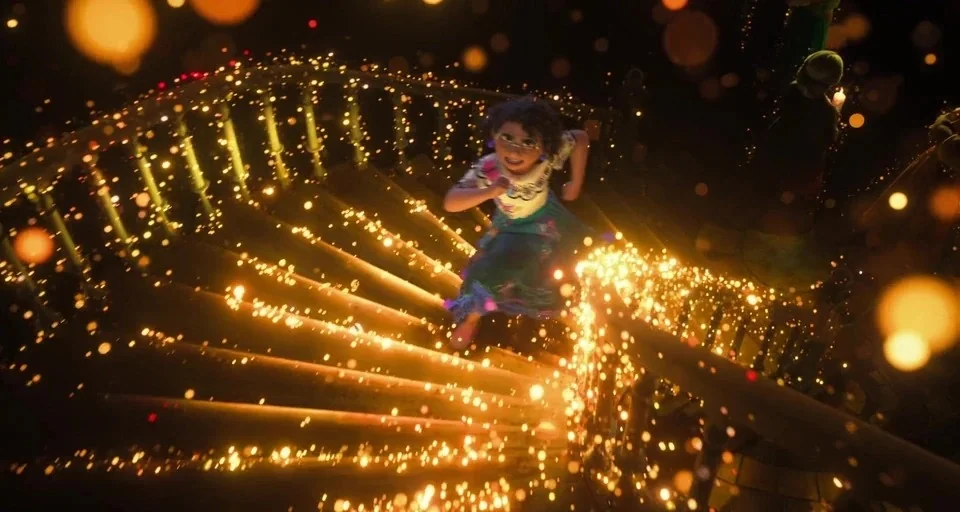 Encanto (2021) movie still: fullbody — A dark grand staircase is illuminated by dense strings of warm golden fairy lights. A young girl with curly…