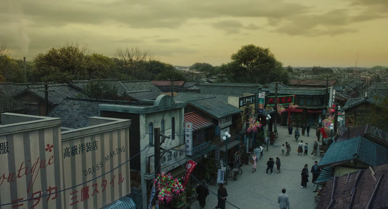 No Longer Human (2019) movie still: establishing — A Japanese town street with traditional dark tile roofs and storefronts with Japanese signs.…