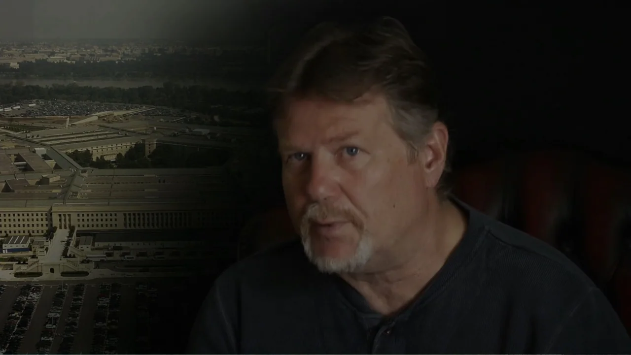 UFO Conspiracies: The Hidden Truth (2020) movie still: closeup — A man is positioned in the foreground with an aerial view of a building behind. The…
