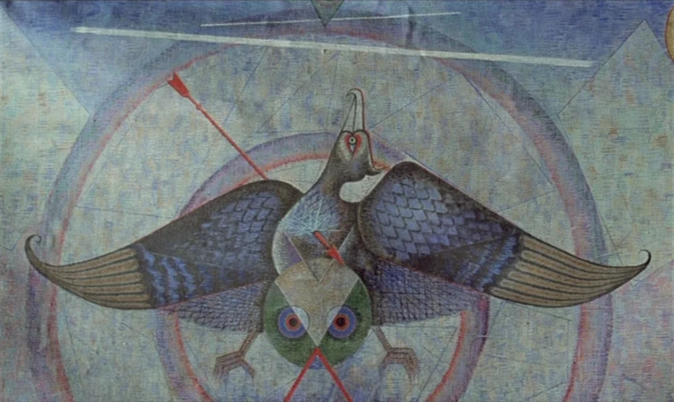 Mr. Klein (1976) movie still: closeup — A detailed wall mural depicts a stylized eagle surrounded by geometric circles and lines. The bird is shown…