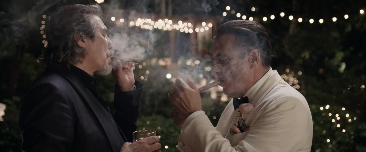 Father of the Bride (1991) movie still: medium — Two men stand in a dimly lit outdoor garden at a wedding reception. They are facing each other…