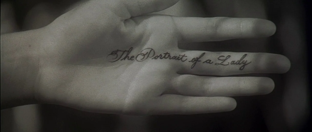 The Portait of a Lady (1996) movie still: closeup — A close-up shot of an open human palm displays elegant cursive black script. The text reads The…