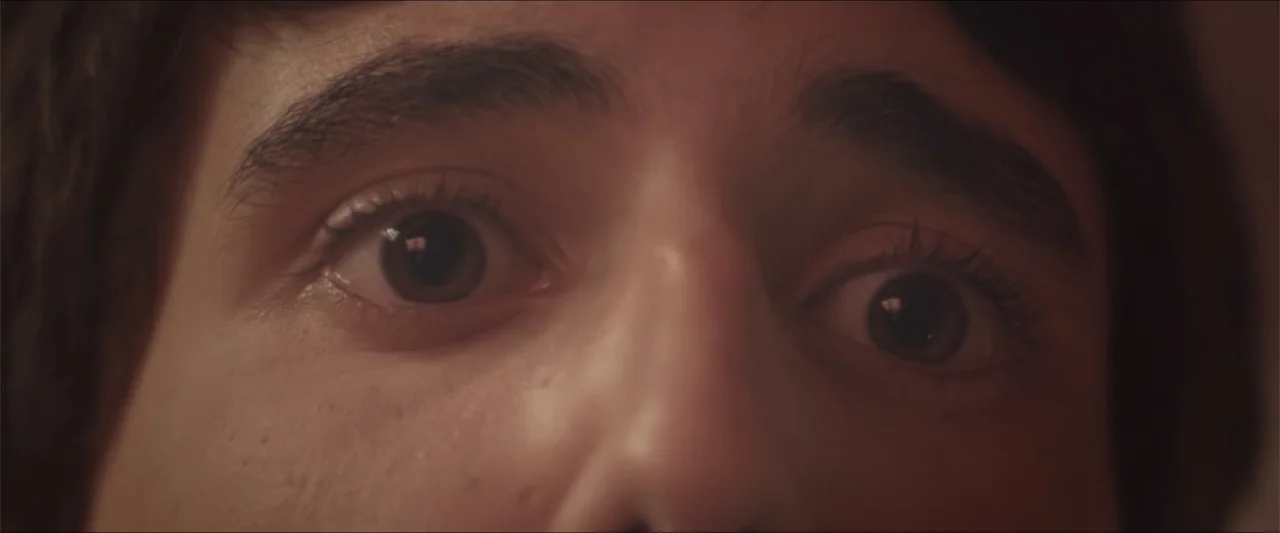 High Five (2004) movie still: closeup — A close-up view of a young man's face fills the frame completely. The subject stares directly forward with…