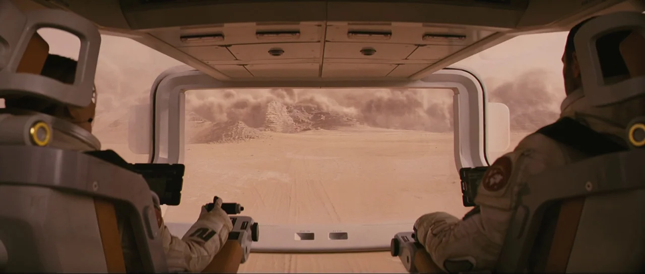 The Last Days On Mars (2013) movie still: wide — The interior of a spacecraft cockpit features white panels and a large transparent viewport. Two…