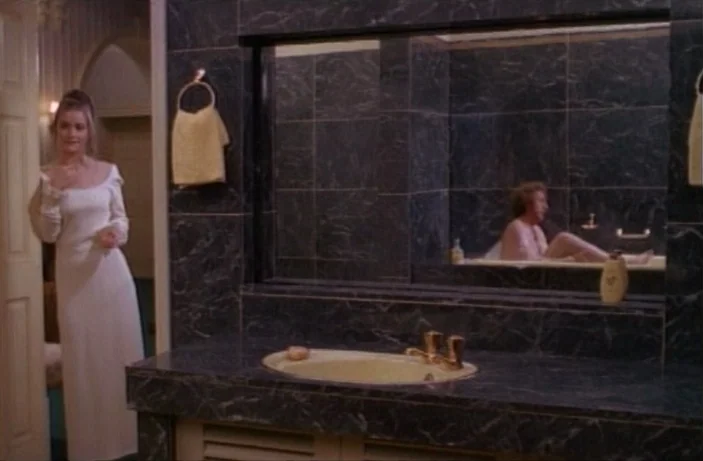 Quackser Fortune Has a Cousin in the Bronx (1970) movie still: medium — A spacious bathroom finished with dark, veined marble tiles and beige…
