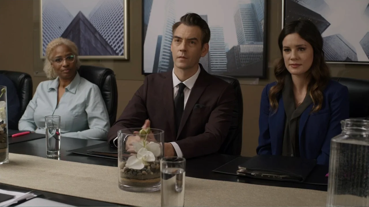 Always and Forever Christmas (2019) movie still: medium — A modern boardroom features a long dark table with glass vases and framed cityscapes.…