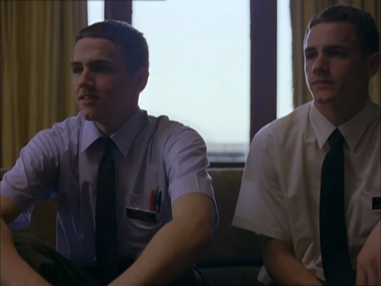 Last Days (2005) movie still: medium — Two young men in formal dress shirts and neckties sit on a sofa. They are positioned in front of a window…