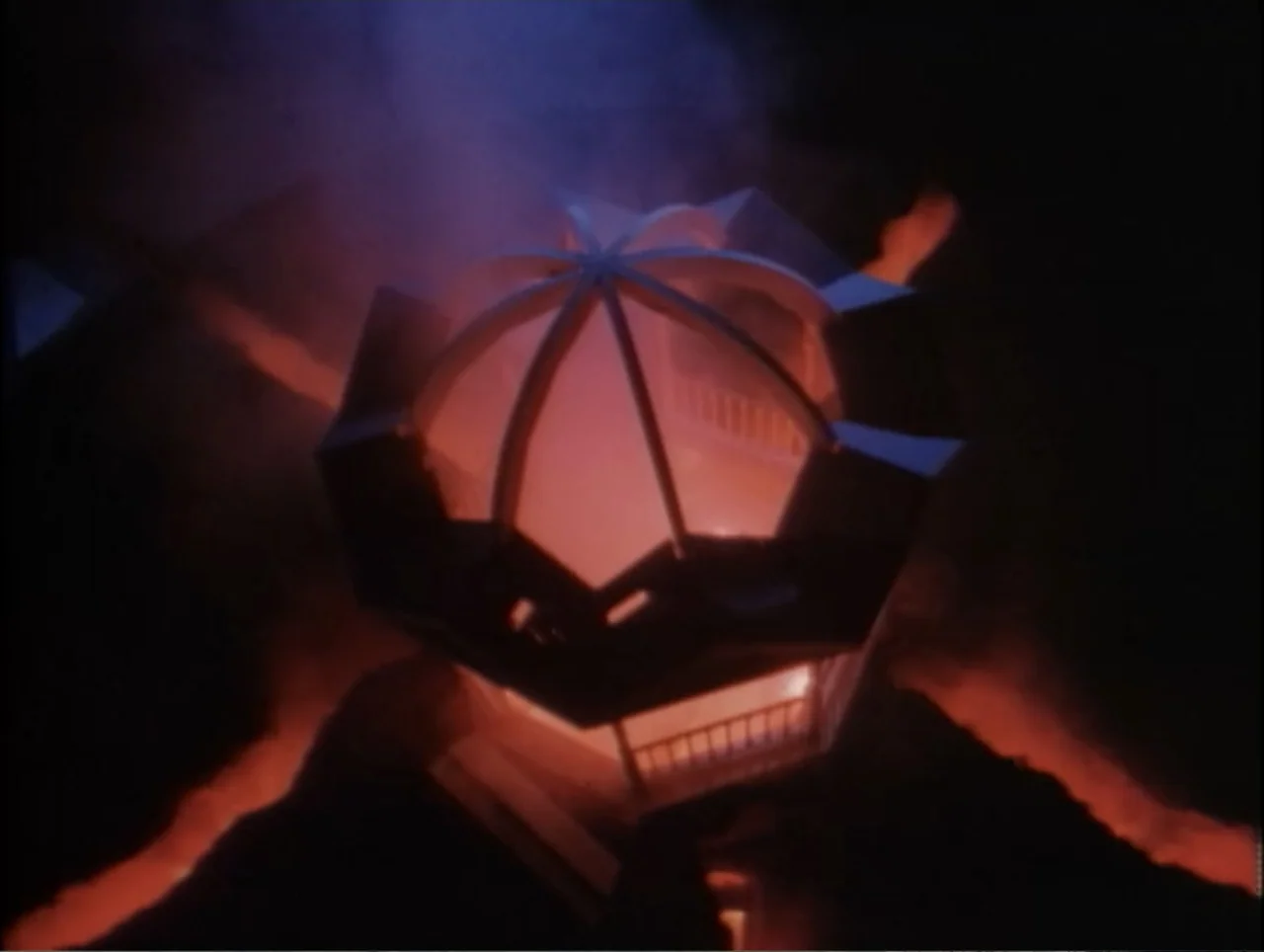 Cast a Deadly Spell (1991) movie still: establishing — A dark volcanic terrain surrounds a central glowing architectural dome emitting red smoke.…