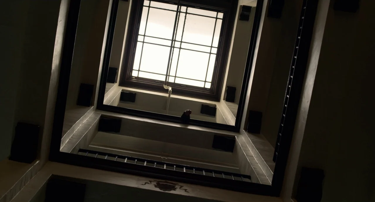 Velvet Buzzsaw (2019) movie still: establishing — A vertical view looking straight up through an interior building atrium towards a skylight.…