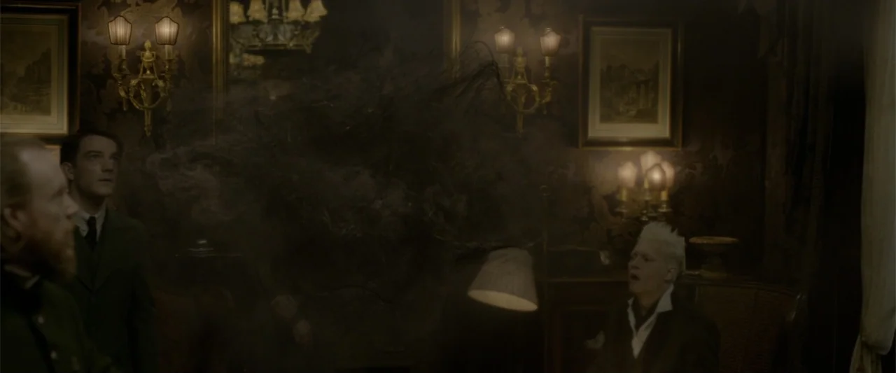 Fantastic Beasts: The Crimes of Grindelwald (2018) movie still: medium — A dimly lit 1920s parlor room featuring ornate dark wallpaper and vintage…