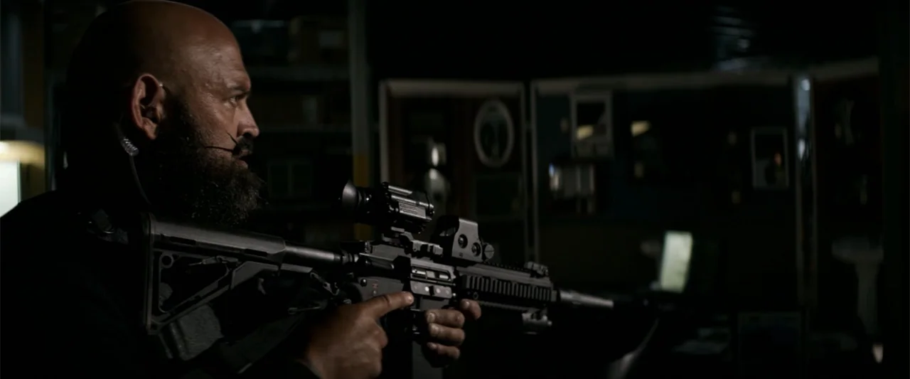 The Equalizer (2014) movie still: medium — A dark tactical command center features modular partitions and illuminated monitors in the background. A…