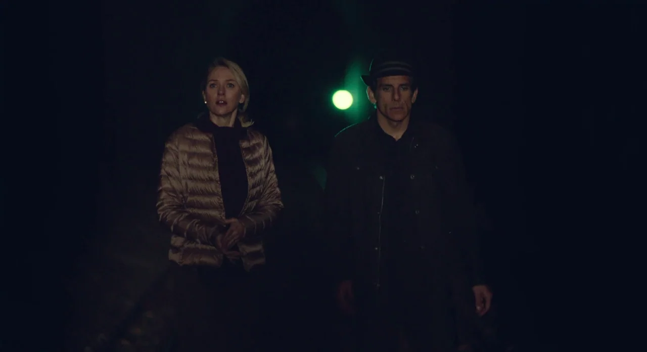 While We’re Young (2014) movie still: medium — A dark outdoor space is illuminated by a single distant green neon light source. A woman and a man…