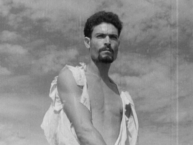Redes (1936) movie still: medium — A man stands against a backdrop of a vast, overcast sky. The subject wears a worn white shirt while looking…