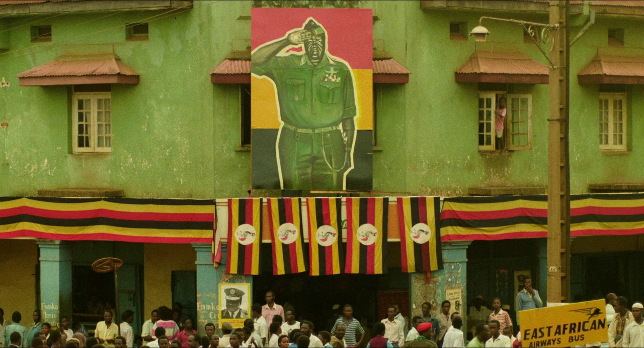 Mississippi Masala (1991) movie still: wide — A green stucco building displays a large painted portrait of a saluting military officer. Multiple…