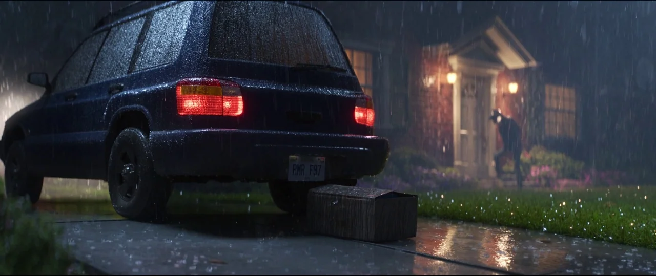 Toy Story 4 (2019) movie still: wide — A dark blue SUV is parked on a wet residential driveway during a storm. A cardboard box rests on the pavement…