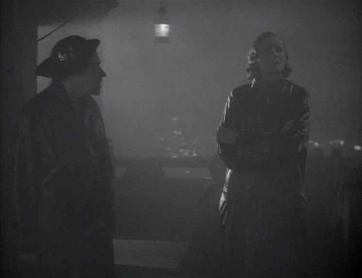 Anna Christie (1930) movie still: medium — A dark, atmospheric dockside location is filled with thick fog and low visibility. A man and a woman…