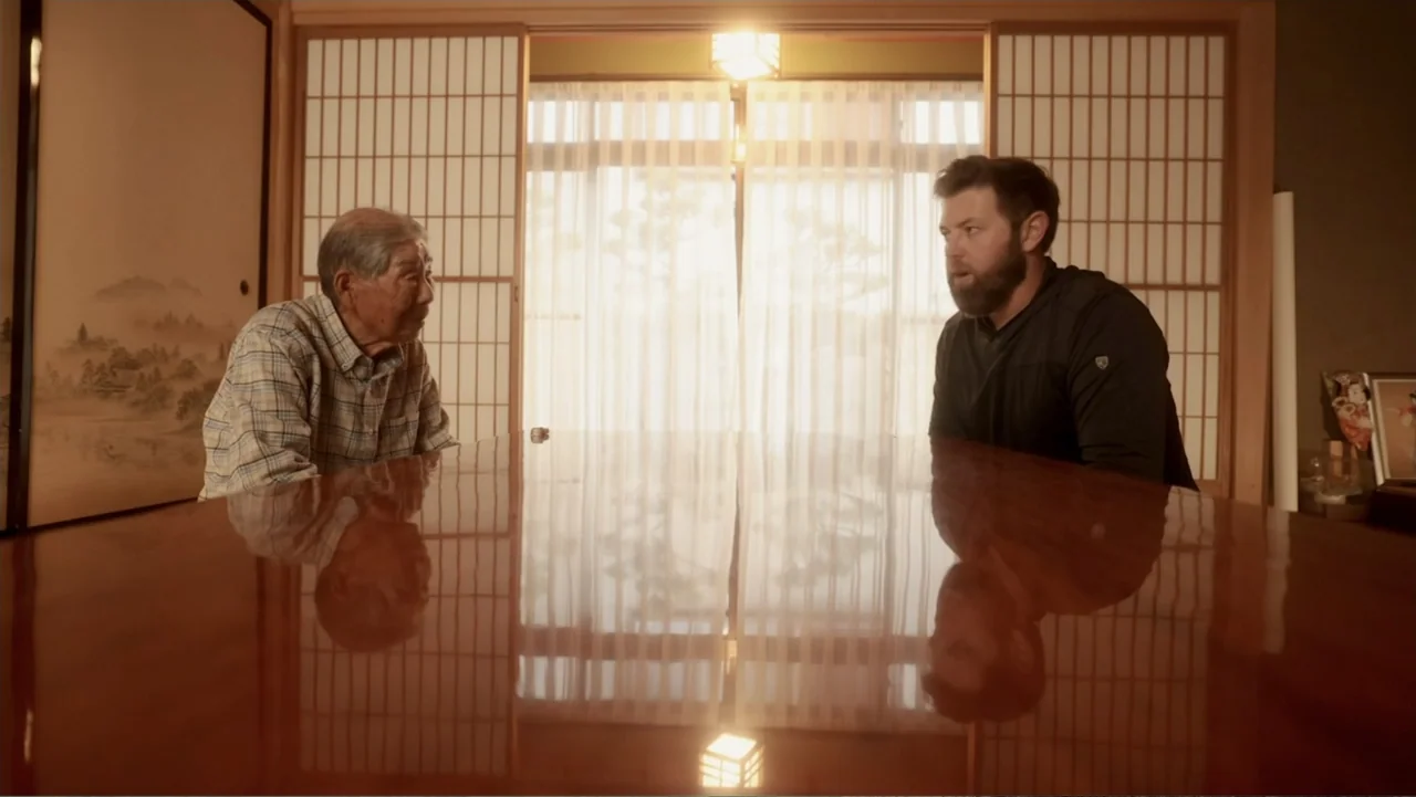 Alien Sharks: Ghosts of Japan (2024) movie still: medium — A traditional room features shoji screens and a large, highly reflective wooden table.…