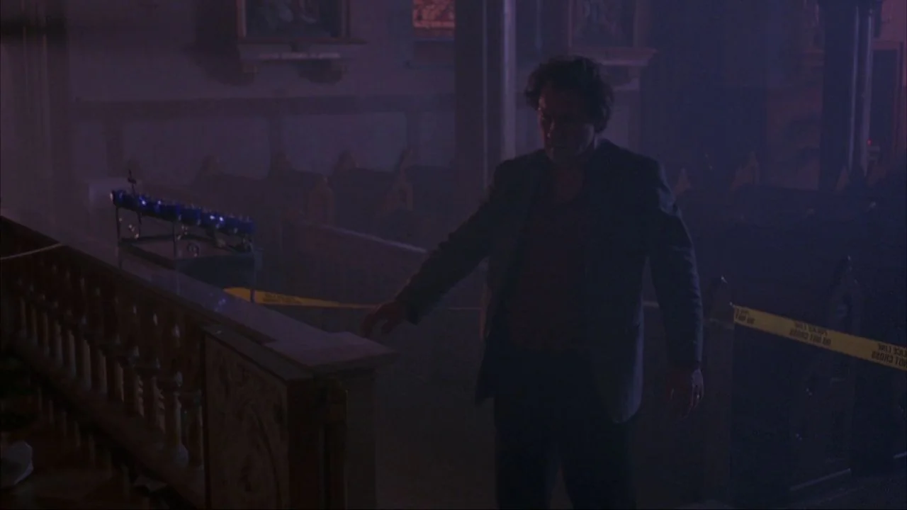 Bad Lieutenant (1992) movie still: medium — A dark church interior is filled with haze and cordoned off with yellow tape. A man moves through the…
