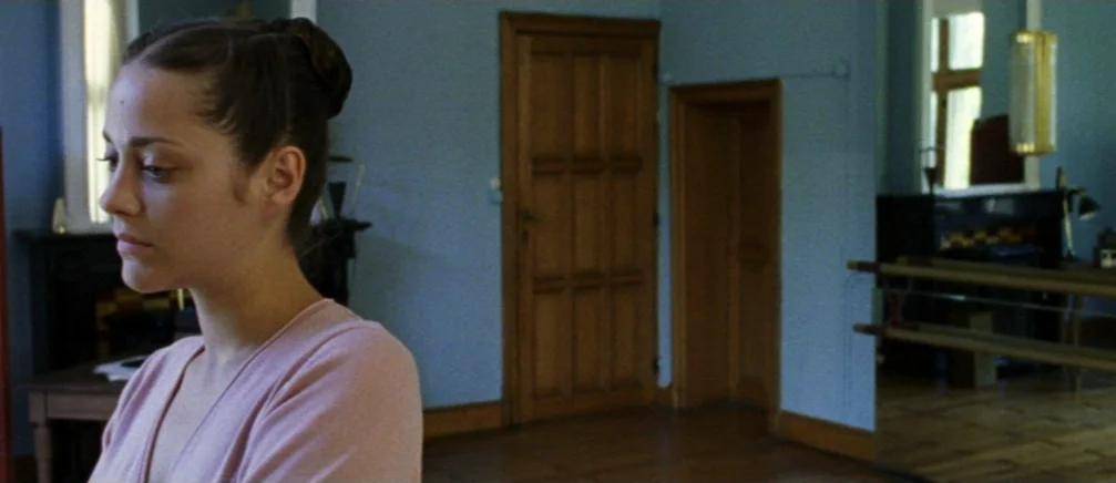 Innocence (2005) movie still: medium — A spacious room features light blue walls, wood-paneled doors, and a ballet barre. A woman in a pink shirt…