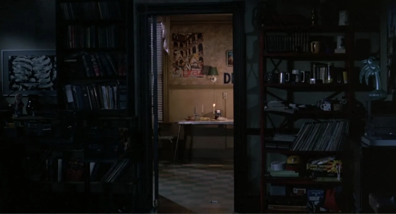 An Experiment in Fear: The Making of Monkey Shines (2014) movie still: wide — A dark, cluttered living room foreground frames a brighter interior…