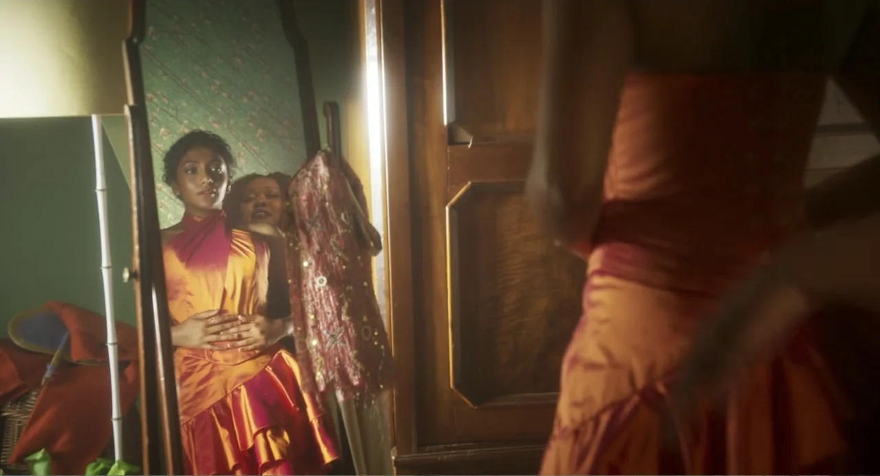 How to Date Billy Walsh (2024) movie still: medium — A dimly lit bedroom features a standing mirror with a dark wood frame. A young woman views her…