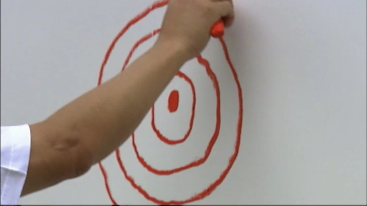 White Light/Black Rain: The Destruction of Hiroshima and Nagasaki (2007) movie still: closeup — A plain white board serves as the background for a…
