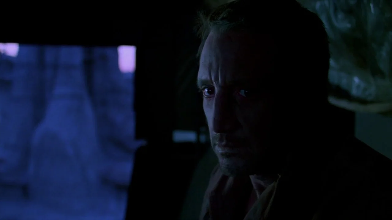 Sorcerer (1977) movie still: closeup — A dark, cramped interior of a vehicle during the early blue hour. A middle-aged man stares out the window…