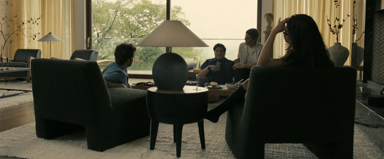 Companion (2025) movie still: wide — A spacious, modern interior features minimalist furniture and a large glass wall outdoors. Four friends are…
