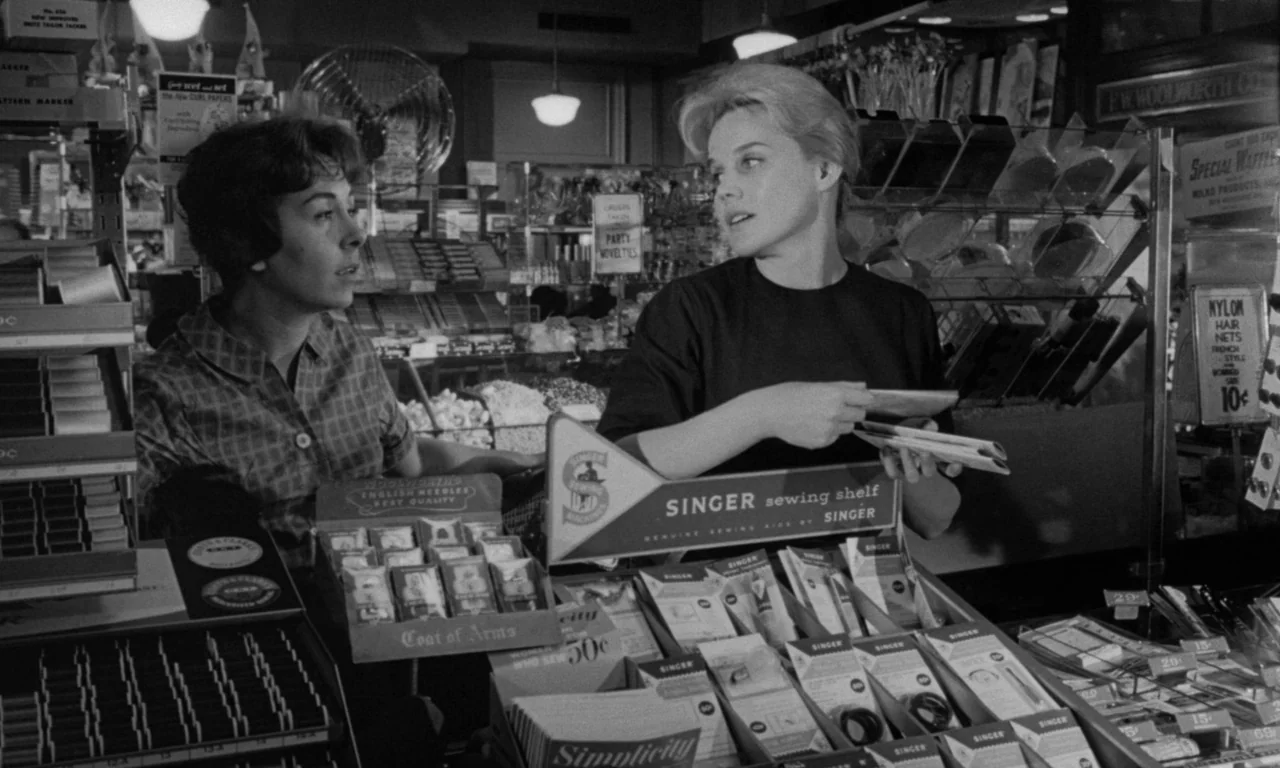 Something Wild (1961) movie still: medium — A 1960s Woolworths store counter filled with various sewing supply boxes and marketing displays. Two…