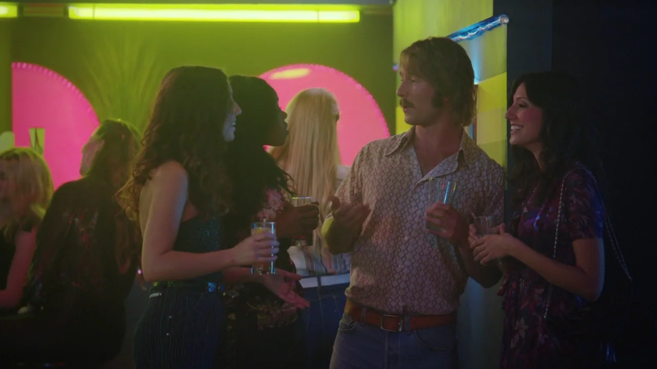Everybody Wants Some!! (2016) movie still: medium — A dimly lit nightclub features neon pink circle accents and hanging green overhead tubes. A man…