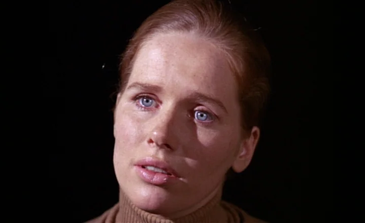 The Passion of Anna (1969) movie still: closeup — A woman stands against a solid black background. She looks toward the side of the frame.