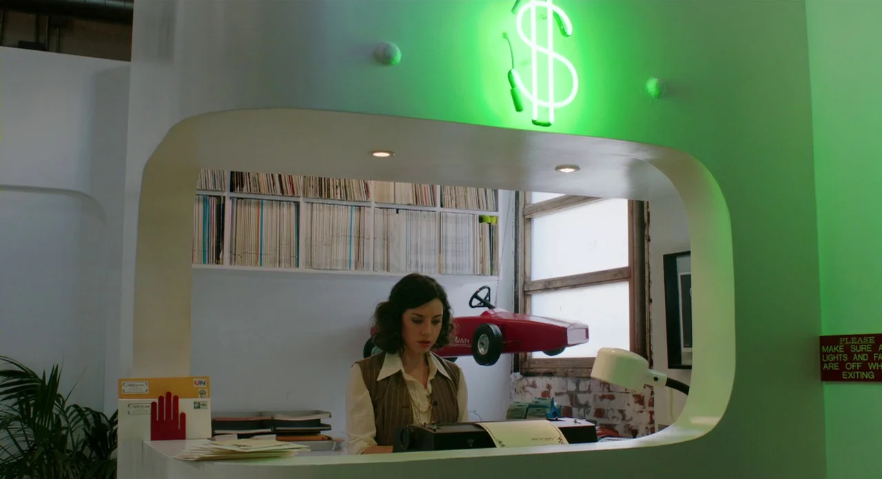 A Glimpse Inside The Mind Of Charles Swan III (2013) movie still: medium — A modern reception area features a white curved desk and white walls with…