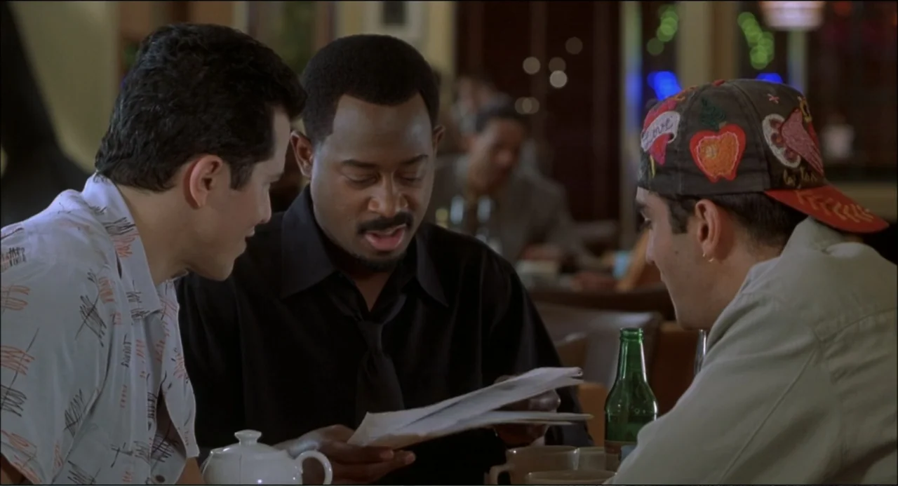 What's the Worst That Could Happen? (2001) movie still: medium — An indoor dining area features a booth with three men gathered around a table. The…