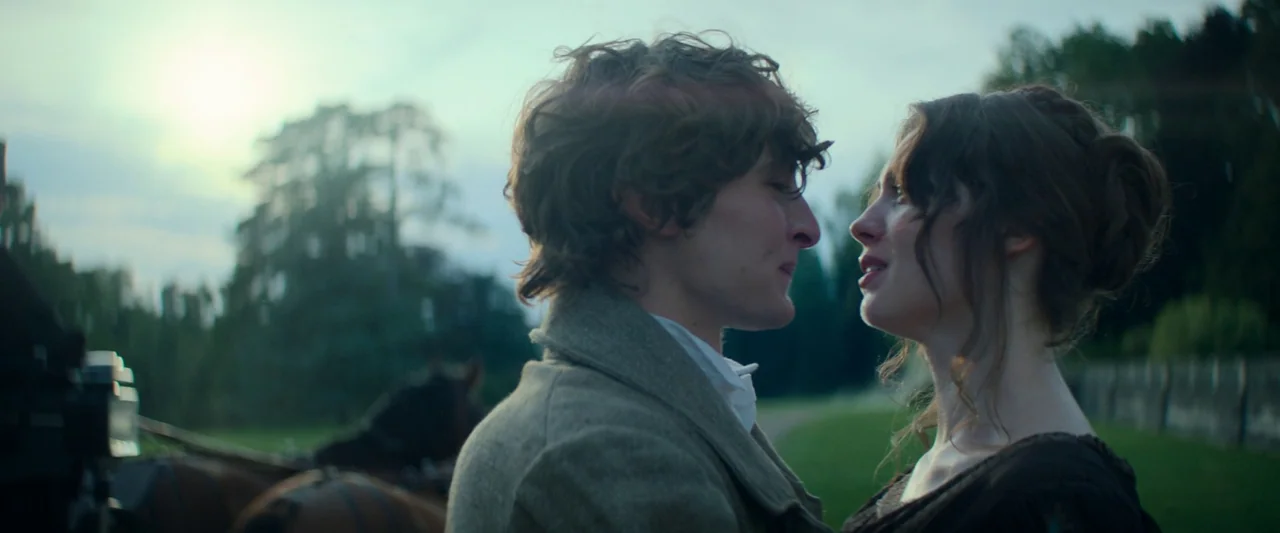 The Count of Monte-Cristo (2024) movie still: medium — An open grassy field during sunset features a man and woman standing together. The pair look…