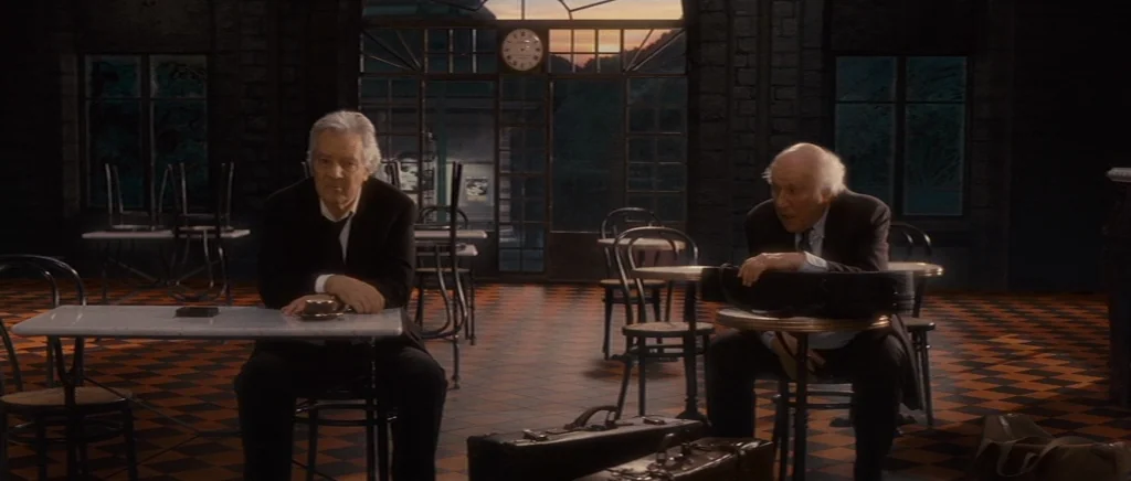 You Ain’t Seen Nothin’ Yet (2012) movie still: wide — An interior cafe features dark brick walls and a checkered floor with sunset light. Two…