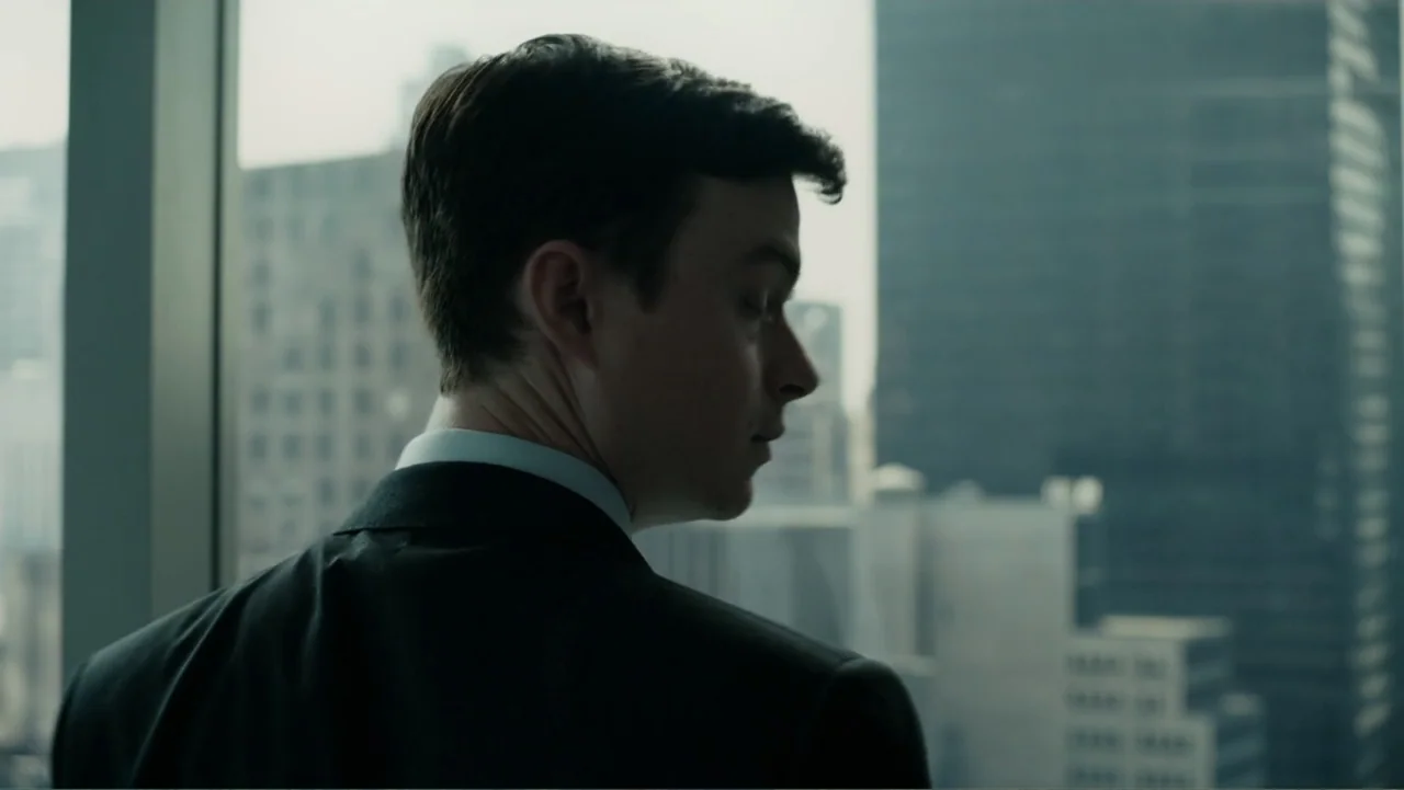 A Cure for Wellness (2017) movie still: medium — A modern corporate skyscraper office features a floor-to-ceiling glass window overlooking a city. A…