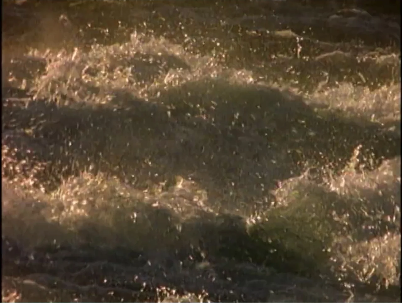 America Undercover: Life Afterlife (2000) movie still: establishing — Turbulent river water flows rapidly over submerged rocks under low-angled warm…