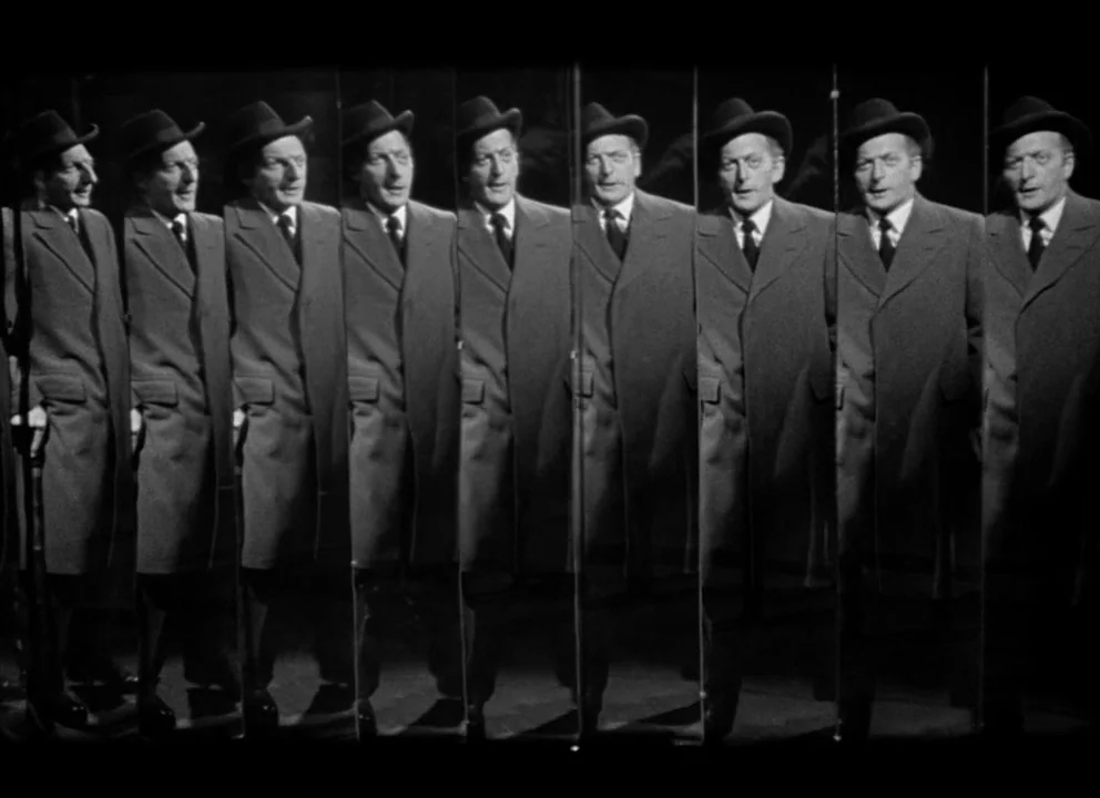 The Lady from Shanghai (1947) movie still: fullbody — An interior space filled with multiple vertical mirror panels reflecting a single man. The man…