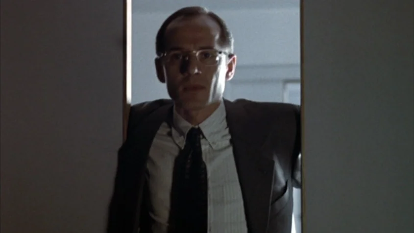 Benny’s Video (1992) movie still: medium — A man stands in an open doorway of a brightly lit room. The man faces the camera while framed by the…