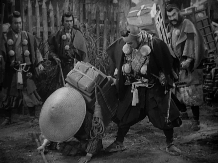 The Men Who Tread on the Tigers Tail (1945) movie still: medium — A group of Japanese men wearing traditional samurai attire stand on a dusty path.…