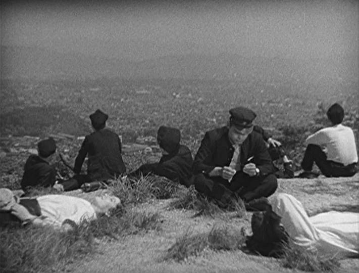 No Regrets for Our Youth (1946) movie still: wide — A grassy hilltop overlooking a distant sprawling city landscape under a bright, hazy sky.…