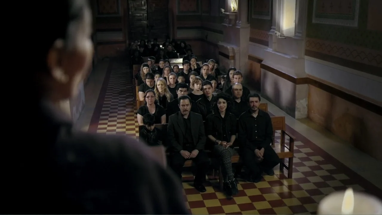 Loco Love (2003) movie still: medium — A church interior with wooden pews and a red and yellow checkered tile floor. A congregation sits in rows…