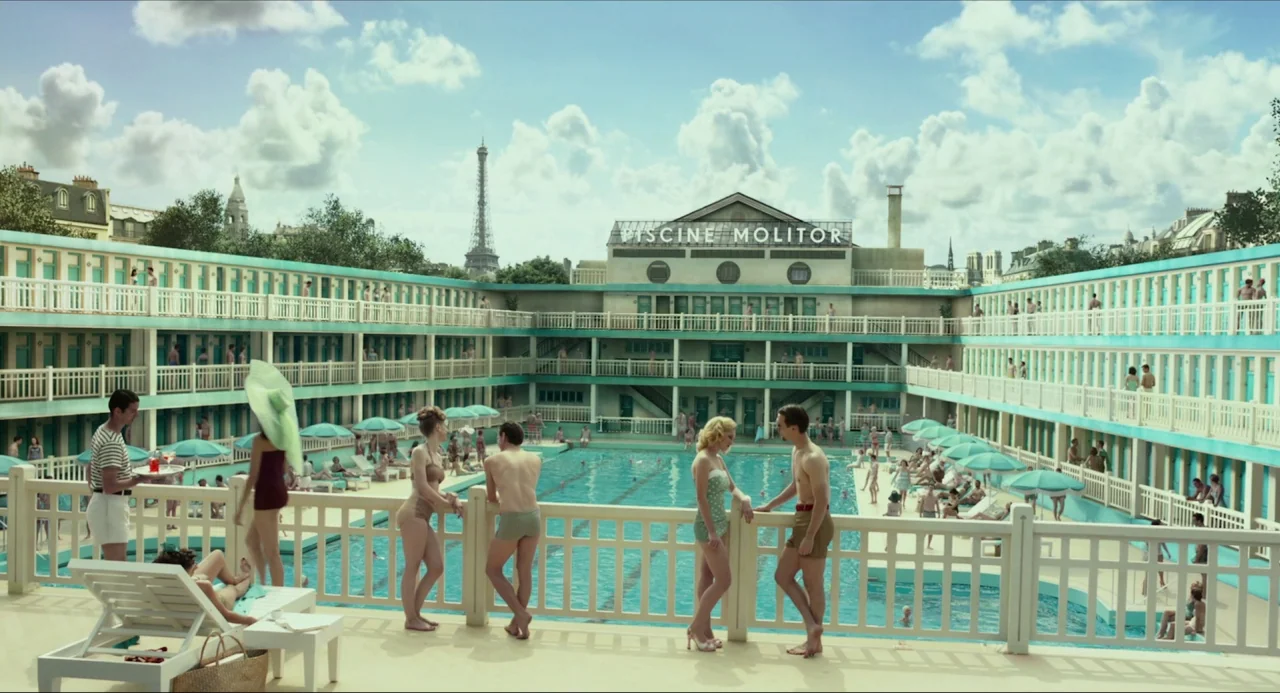 Life of Pi (2012) movie still: wide — A historic Art Deco swimming pool complex in Paris features a prominent central building. Several people stand…