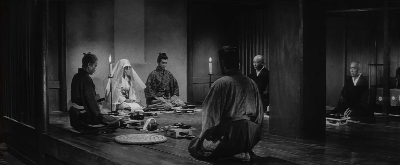 Harakiri (1962) movie still: wide — A dark, spare room with wooden floorboards and shoji screen partitions. Six individuals sit on tatami mats…