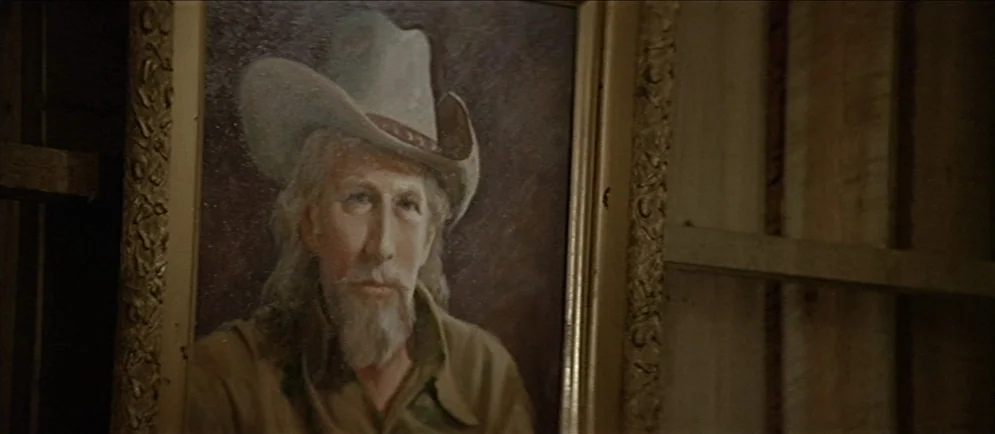 Buffalo Bill and the Indians, or Sitting Bull’s History Lesson (1976) movie still: closeup — An oil painting of an older man in a cowboy hat is…