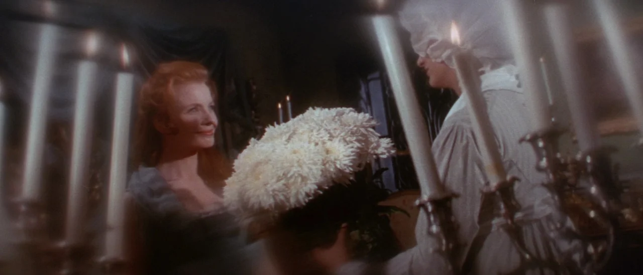 The Tomb of Ligeia (1964) movie still: medium — A dimly lit room contains two women gathered near a candelabra. A large bouquet of white flowers…