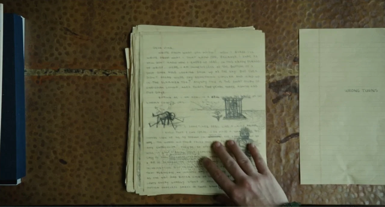 Bad Boys: A True Story (2003) movie still: closeup — A top-down view shows a thick stack of yellowed, handwritten pages on a copper-colored desk. A…