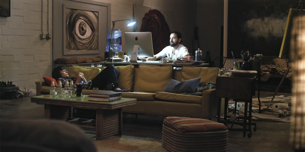 Stalked by My Doctor: A Sleepwalker's Nightmare (2019) movie still: wide — A dimly lit industrial loft features artwork on the walls and a…